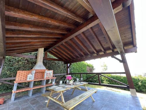 a patio with a wooden roof and a table at Magnífica villa mirando al mar in Suances