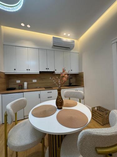 a kitchen with a white table and chairs at Silver Stone Suites in Gjirokastër