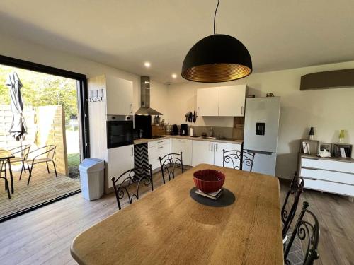 une cuisine et une salle à manger avec une table et des chaises dans l'établissement Résidence 120-grayan Et L Hopital - 120 - Séjour idéal pour des moments en famille ou entre amis MAE-9781, à Grayan-et-lʼHôpital