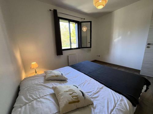 une chambre avec un grand lit avec deux oreillers dessus dans l'établissement Résidence 120-grayan Et L Hopital - 120 - Séjour idéal pour des moments en famille ou entre amis MAE-9781, à Grayan-et-lʼHôpital