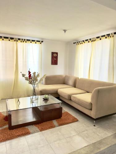 a living room with a couch and a coffee table at Casa Acogedora y Amoblada in Buga