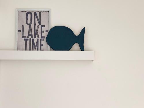 a shelf with a black whale on a white wall at Aquavista Residence - Lakeview Holiday Apartments with Pool in Dormelletto