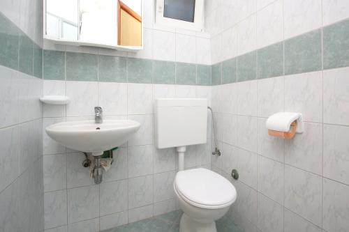 a bathroom with a toilet and a sink at Apartments and Rooms Vesna Novalja in Novalja