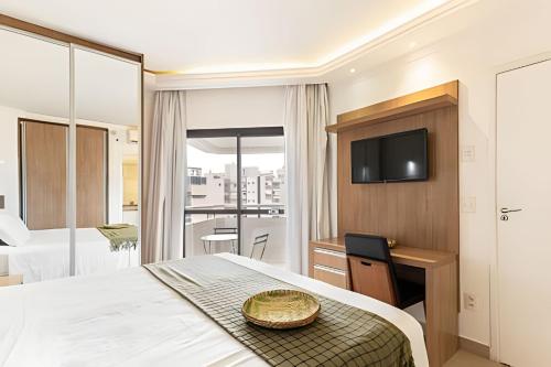 ein Hotelzimmer mit einem Bett und einem Fernseher in der Unterkunft ARK Houses - Flat Vista-Mar - Piscina na Cobertura in Santos