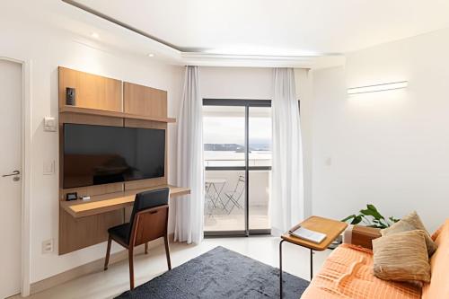 ein Wohnzimmer mit großem Fernseher und Couch in der Unterkunft ARK Houses - Flat Vista-Mar - Piscina na Cobertura in Santos