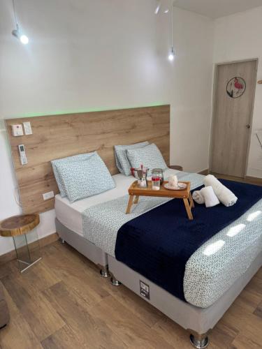 a bedroom with a bed with a table on it at Comunidad Calle 13 Hotel Boutique in Santa Marta