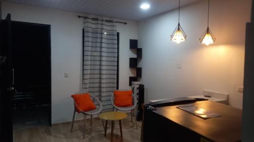 a living room with orange chairs and a table at Apartamento 5 in Leticia