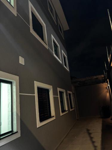 a building with windows on the side of it at night at Hachi Flats - GRU in Guarulhos
