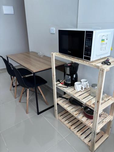 a microwave oven sitting on top of a wooden table at Hachi Flats - GRU in Guarulhos