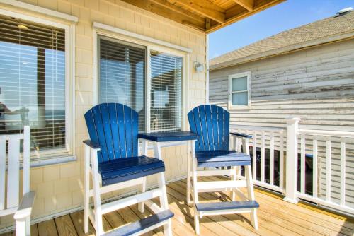 a pair of blue chairs on a porch at Next Time Down by Carolina Beach Realty in Kure Beach