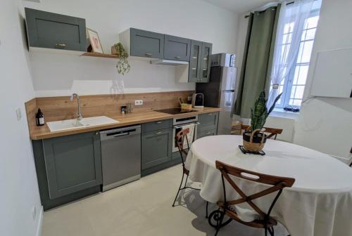 a kitchen with green cabinets and a table and a sink at La calanque bleue - Maison de 65m2 plein centre in Martigues