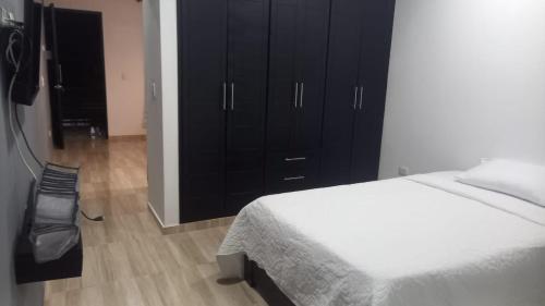 a bedroom with a bed and a black cabinet at Apartamento 5 in Leticia