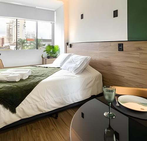 a hotel room with a bed and a table at ARK Houses Gonzaga - Reformado 200m da Praia in Santos