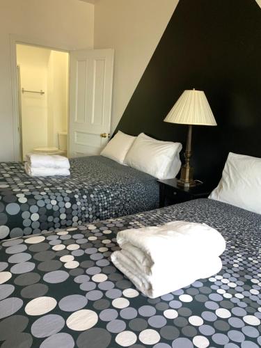 a hotel room with two beds and a lamp at Pensione Popolo in Montréal