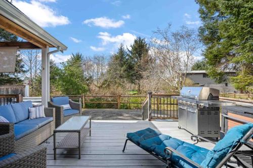 a patio with a couch and a grill on a deck at The Nedonna Nest in Rockaway Beach