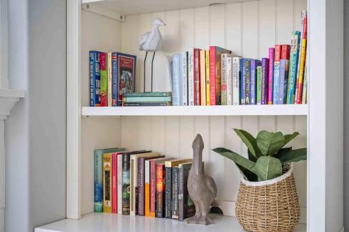 a book shelf filled with books next to a potted plant at The Nedonna Nest in Rockaway Beach