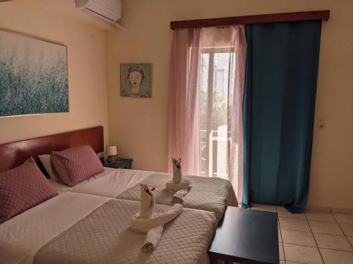 a bedroom with two beds and a window at Pension Irene in Sougia