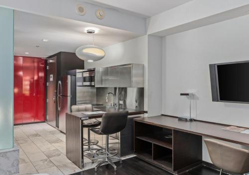 a kitchen with a bar with chairs and a tv at Palms Place Condo Hotel & Casino in Las Vegas