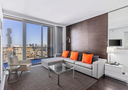 a living room with a couch and orange pillows at Palms Place Condo Hotel & Casino in Las Vegas