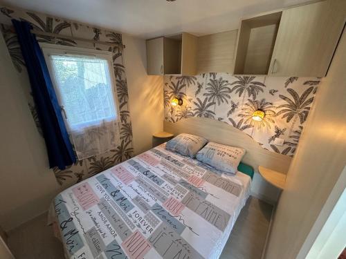 Un dormitorio pequeño con una cama y una ventana. en Chalet de jardin, piscine, en Seignosse