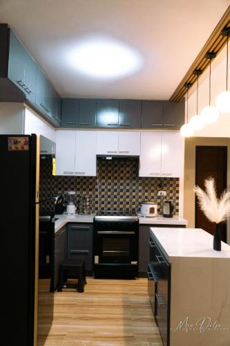 a kitchen with black cabinets and a white counter top at Gray Farmhouse in Buliwao