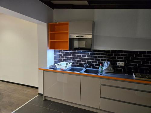 a kitchen with a sink and a microwave at Yaël House in Brussels
