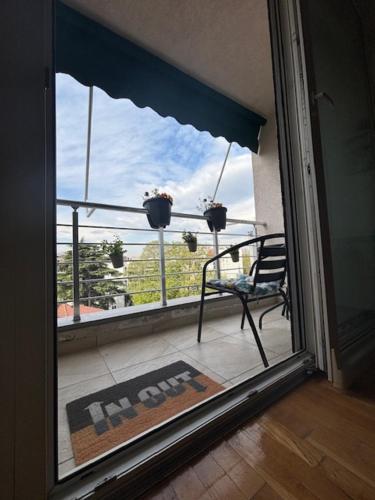 an open door to a balcony with a chair on a porch at Goca Apartment in Skopje