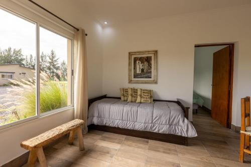ein Schlafzimmer mit einem Bett und einem großen Fenster in der Unterkunft La Joaquina in Rosario de Lerma