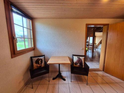 a table and two chairs in a room with a window at Apartment Simcha in Niederwichtrach