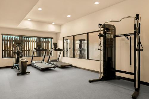 a gym with tread machines and mirrors in a room at LivAway Suites Missoula in Missoula