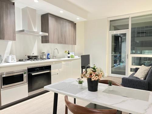 a white kitchen with a table and a couch at Best location &comfortable room1B &1B Richmond center in Richmond