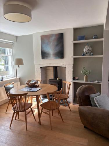 a living room with a table and chairs and a fireplace at Billie's seaside retreat in Lyme Regis