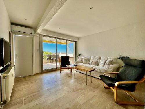 un salon avec un canapé et une table dans l'établissement Entre Mer & Port - T3 Carnon, Terrasse, Clim, à Mauguio