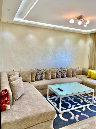 a living room with a couch and a table at luxueux appartement vue piscine in Oualidia