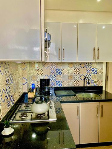 a kitchen with a stove with a tea pot on it at luxueux appartement vue piscine in Oualidia