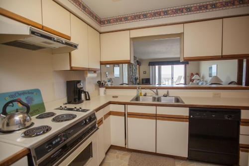a kitchen with a stove and a sink at Ocean Dunes 1001 by Carolina Beach Realty in Kure Beach