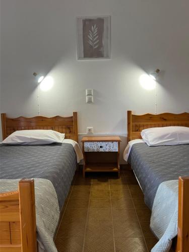 a hotel room with two beds and a table at ERIDA Accommodation in Lákka