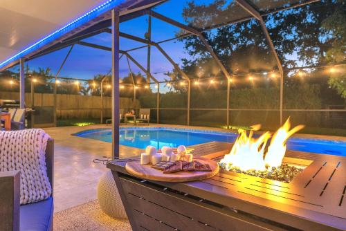 eine Terrasse mit einer Feuerstelle neben einem Pool in der Unterkunft Family Beach Home With Home Theater & Heated Pool! in Hollywood