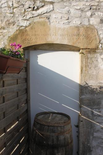 a garage with a stone wall and a barrel at Charmante Maison Pierres 1768 in Polisy
