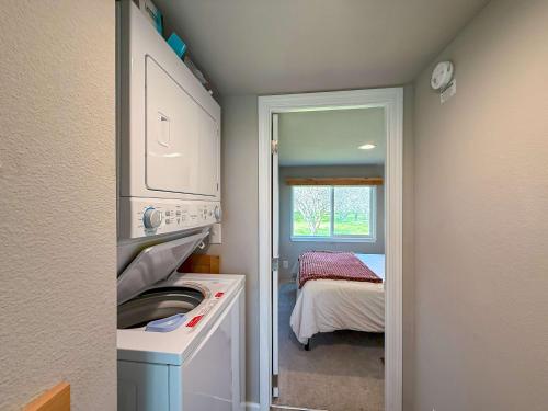 a small kitchen with a washer and dryer next to a bedroom at Apple Blossom Bungalow in Sequim