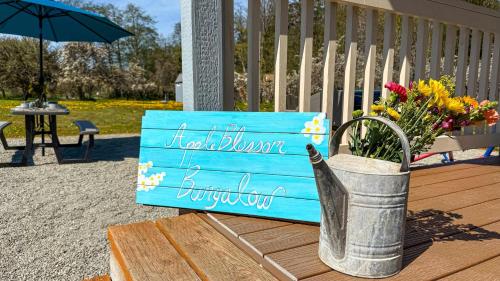 a sign on a bench with flowers in a bucket at Apple Blossom Bungalow in Sequim