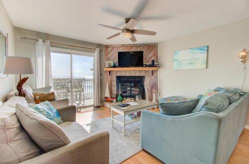 a living room with a couch and a fireplace at Ocean Dunes 1504 by Carolina Beach Realty in Kure Beach