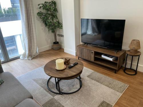 a living room with a television and a coffee table at Zone 1 Bright and Modern 3 Bed Apt Hyde Park Central London in London