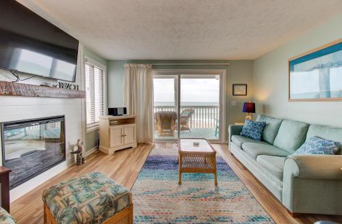 a living room with a couch and a fireplace at Ocean Dunes 2101A by Carolina Beach Realty in Kure Beach