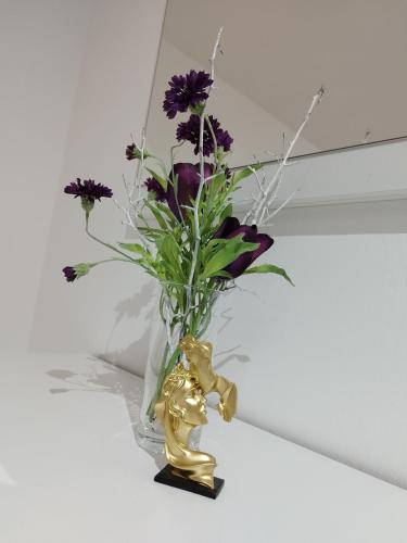 a vase filled with purple flowers sitting on a table at Tolj apartman in Ljubuški