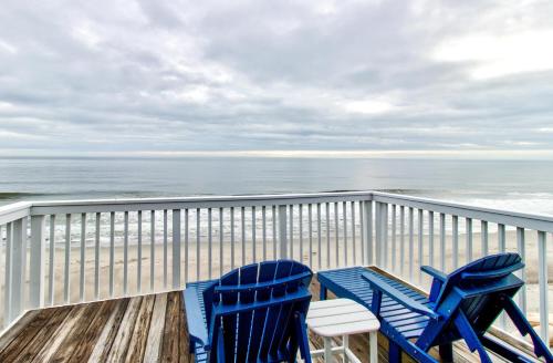 two blue chairs sitting on a deck overlooking the beach at Ocean Dunes 2124C- Bella Vista by Carolina Beach Realty in Kure Beach