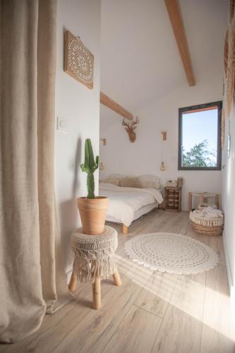 Cette chambre comprend un lit et un cactus. dans l'établissement Modern Villa Close to Beach, à Tarnos