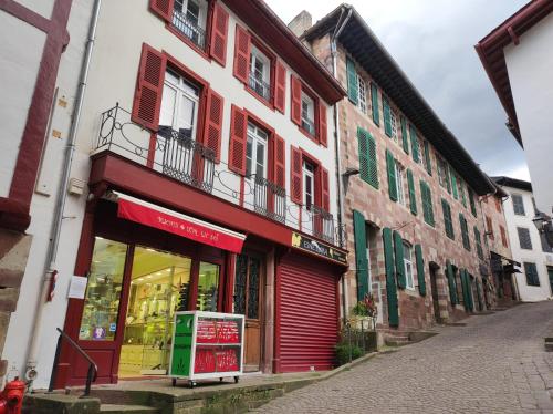 a building with red and green trim on a street at Chez Mapi in Saint-Jean-Pied-de-Port