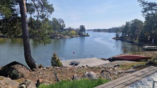 a view of a river with a boat on the shore at Summer cottage at seafront with private jetty in Oskarshamn
