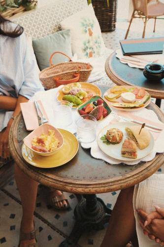 two people sitting at a table with plates of food at Hôtel Font Mourier in Cogolin